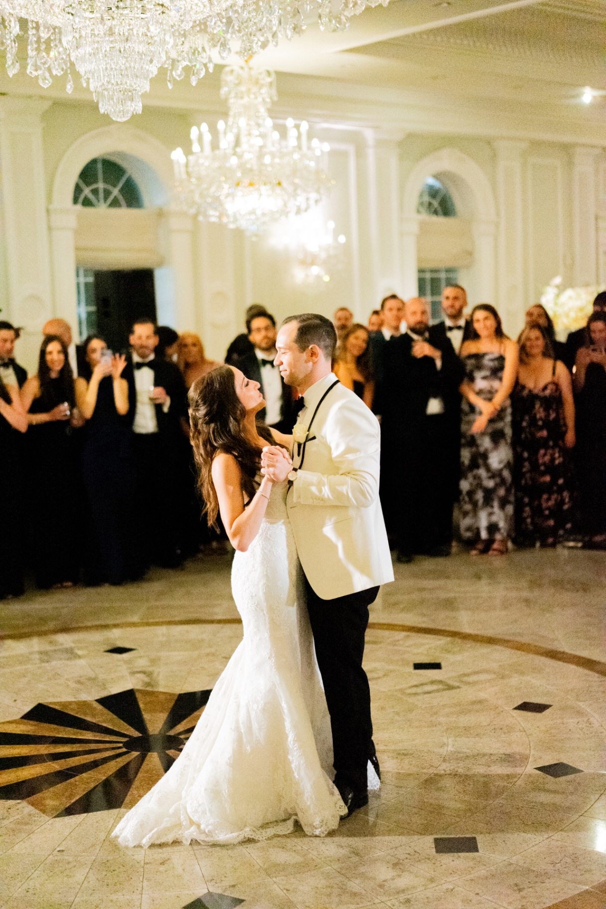 Nikkaela and Marco's first dance beneath crystal chandeliers